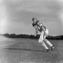 Primary view of [Football player #80, R. Hinch, running across a flat stadium field]