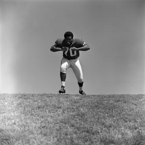 Primary view of object titled '[Football player #70, Jimmy Franklin, runs forward arms in a T, 2]'.