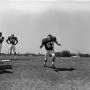 Photograph: [Football player #67, Clyde Herbert, running in the foreground with f…