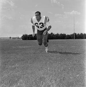 Primary view of object titled '[Football player number 63 running through a football field, 3]'.