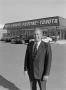 Photograph: [Man standing in front of a Pontiac-Toyota dealership, 4]