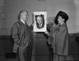 Photograph: [Man and Woman holding a portrait drawing]