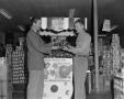 Photograph: [Frank Mills and another man at a grocery store, 2]