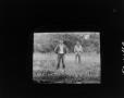 Photograph: [Two men standing in a field]