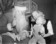 Photograph: [Santa Claus with woman and child]