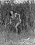 Photograph: [Woman crouching in grass as Ghost River Kid]