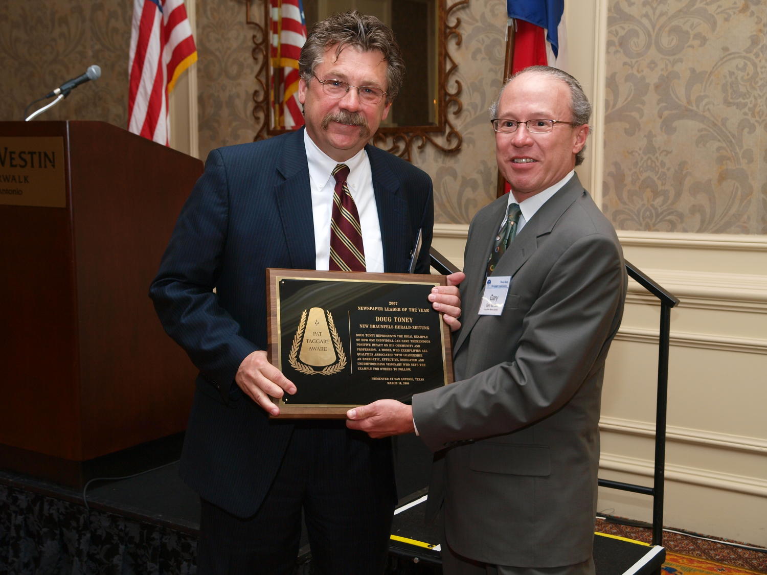 [Doug Toney and Gary Borders], Photograph of Doug Toney (left) receiving an award from Gary Borders during the award ceremony at the 2008 Texas Daily Newspaper Association annual conference awards dinner, held at The Westin Riverwalk Hotel in San Antonio, Texas., 