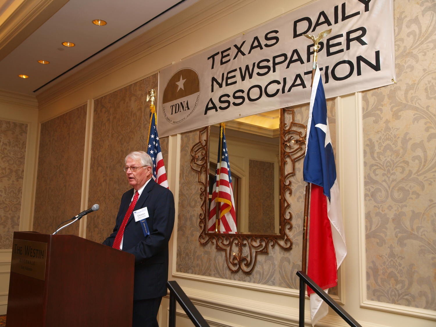 [Charles Moser giving a thank you speech at TDNA meeting], Photograph of Charles Moser standing at a wooden podium and addressing the guests, giving a thank you speech as he has accepted an award, at the 2008 Texas Daily Newspaper Association annual conference awards dinner, held at The Westin Riverwalk Hotel in San Antonio, Texas., 