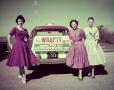 Photograph: [Three Women standing in front of a car WBAP-TV ad]