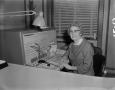 Photograph: [Ruby Hawkins posing at a telephone switchboard]