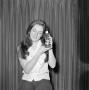 Photograph: [Woman holding a bottle of Prell shampoo]