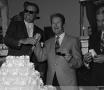 Photograph: [Two men cutting a cake at grand opening]