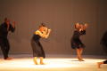 Photograph: [Photograph of three dancers performing on a stage in black outfits]