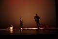 Photograph: [Photograph of dancers performing on a dark stage]