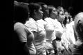Photograph: [Choir members singing while standing in line]