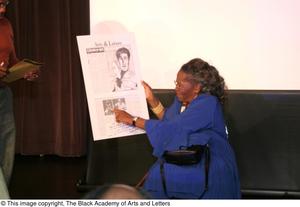 Primary view of object titled '[Irma Hall holding up poster]'.