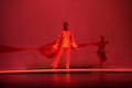 Photograph: [Photograph of a man dancing in front of a strip of fabric]