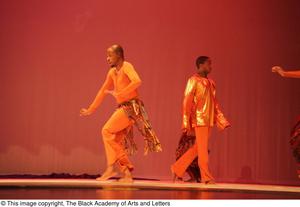 Primary view of object titled '[Photograph of two men standing on stage in orange clothing]'.