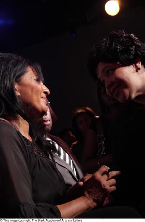 Primary view of object titled '[Pam Grier smiles at woman]'.