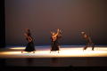 Photograph: [Photograph of six dancers performing on a stage in black clothing]