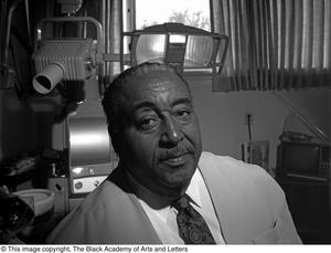 Black and white photograph of Dr. Strotha E. Hardeman Jr. with dental light and x-ray machine behind him.