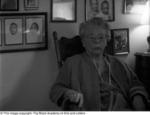 Primary view of object titled '[Photograph of Marzelle Cooper-Hill in her rocking chair, 2]'.