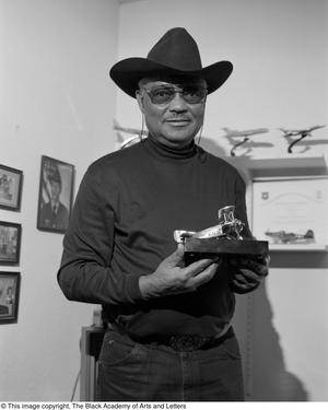 Primary view of object titled '[John F. Briggs holding one of his model airplanes]'.