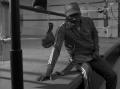 Photograph: [Curtis Cokes sitting on the edge of the boxing ring]