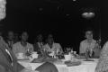 Photograph: [Photograph of a dining table with five unidentified individuals]