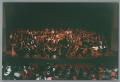 Thumbnail image of item number 1 in: '[Photograph of an orchestra ensemble and choir on a stage]'.