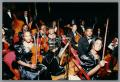 Photograph: [Photograph of a group of string musicians sitting in folding chairs]