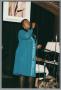 Photograph: [Photograph of a woman on the stage, singing into a microphone]