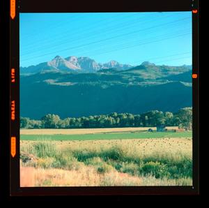 Primary view of object titled '[Photograph of mountains behind a field]'.