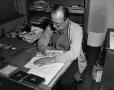 Photograph: [Photo of man writing at desk]