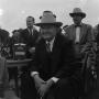 Photograph: [Man in suit and hat sitting]