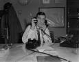 Photograph: [Charles Murphy using two telephones]