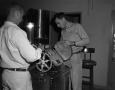 Photograph: [Two men working with film equipment]