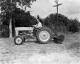 Photograph: [Photograph of Doc Rhuman on a Ford tractor]