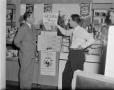 Photograph: [Men leaning on a cigarette display]