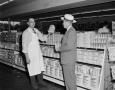 Photograph: [Two men holding Domino Sugar products]
