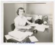 Photograph: [Photograph of Fay Cothern in an office]