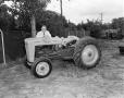Photograph: [Doc Rhuman standing behind a Ford tractor]