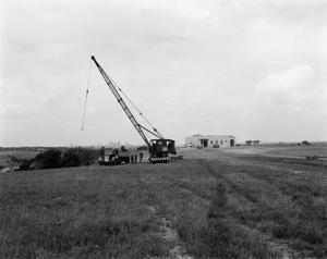 Primary view of object titled '[Photograph of crane and tower in field]'.