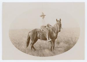Una foto en forma de óvalo. Un hombre está a caballo, llevando las riendas y con una camisa blanca y un sombrero de vaquero.