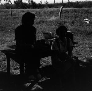 Primary view of object titled '[Photograph of two women sitting at a table outside]'.