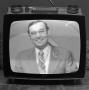 Photograph: [Ron Godbey on a television screen]