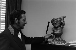 Primary view of object titled '[Guy Woodward Jr. touching a statue]'.
