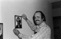 Photograph: [Bill Kelley putting up a framed portrait at KXAS]