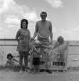Photograph: [Family standing on the beach]