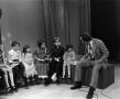 Primary view of [Photograph of Bill Kelley sitting with children at a KXAS Christmas Children's Hour party]